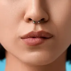 Kobieta z kolczykiem w nosie septum i kolczykami w uszach.