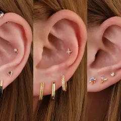 Ucho z kilkoma kolczykami, w tym z ozdobnym triple helix piercingiem i kolorowymi kamieniami.