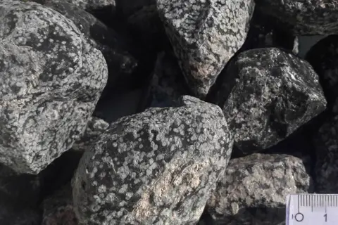 Grupka kamieni, w tym piękny obsydian śnieżny, z widocznymi białymi wtrąceniami na czarnym tle.