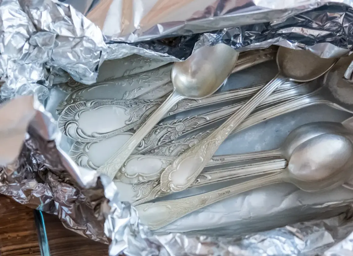 Stare, poczerniałe sztućce ze srebra, gotowe do czyszczenia. Jak wyczyścić poczerniałe srebro? Wystarczy folia aluminiowa i soda.