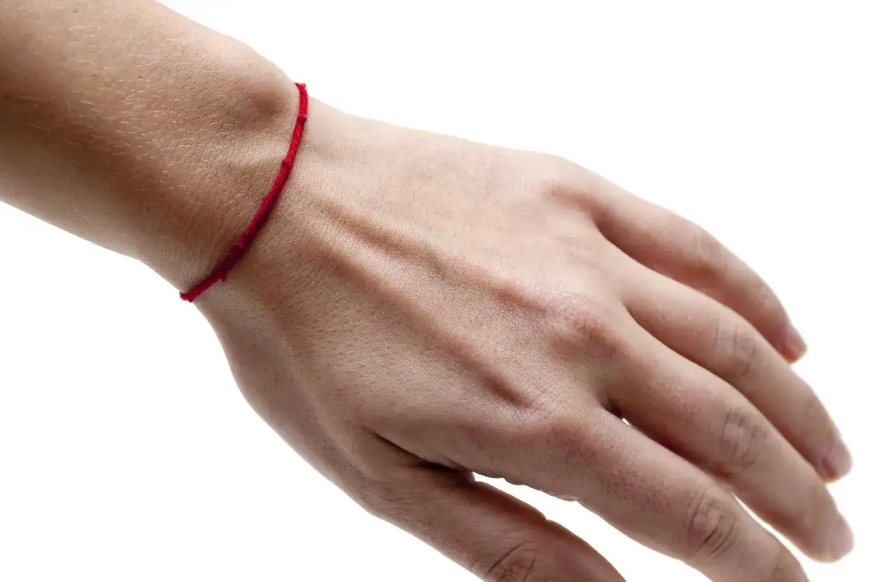 Czerwona nitka na nadgarstku to symbol ochrony i szczęścia. Noszona jako amulet, ma chronić przed złymi urokami i przyciągać pozytywną energię.