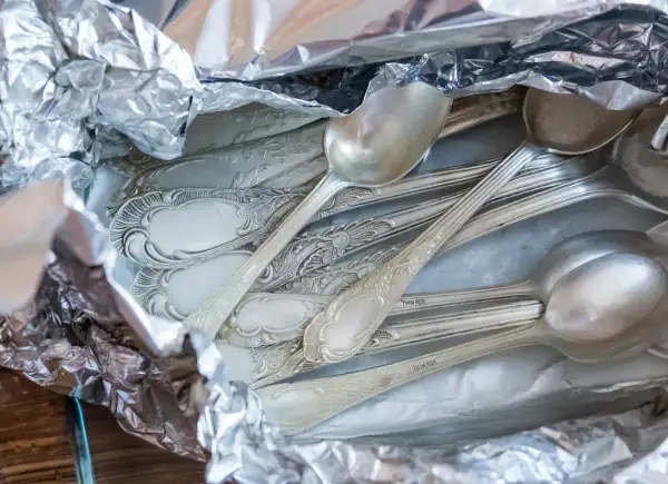 Stare, poczerniałe sztućce ze srebra, gotowe do czyszczenia. Jak wyczyścić poczerniałe srebro? Wystarczy folia aluminiowa i soda.