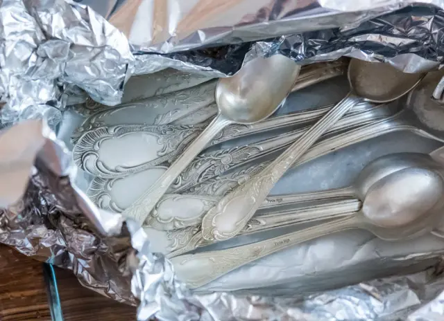 Stare, poczerniałe sztućce ze srebra, gotowe do czyszczenia. Jak wyczyścić poczerniałe srebro? Wystarczy folia aluminiowa i soda.